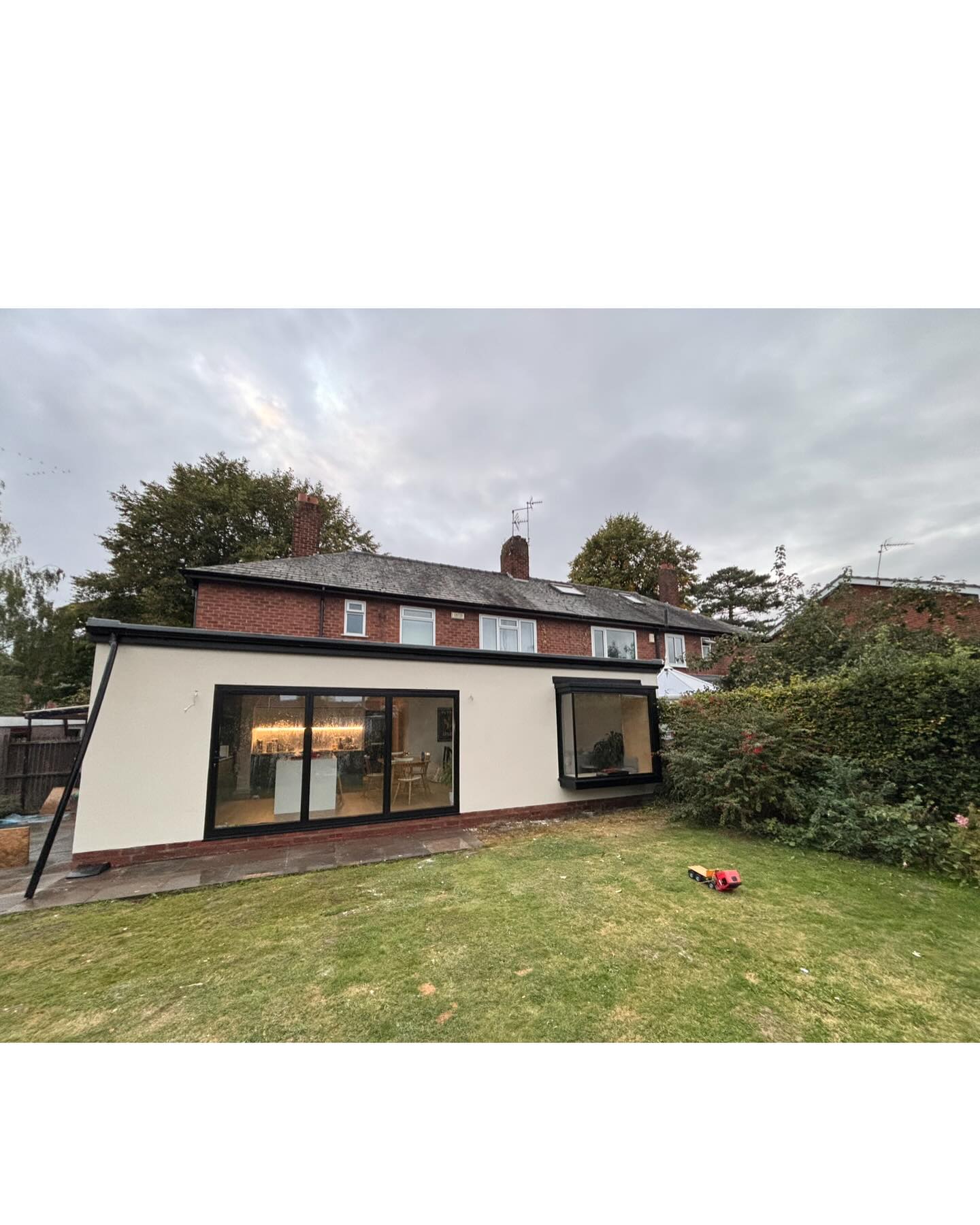 Single-storey extension finished with smooth white render and anthracite windows