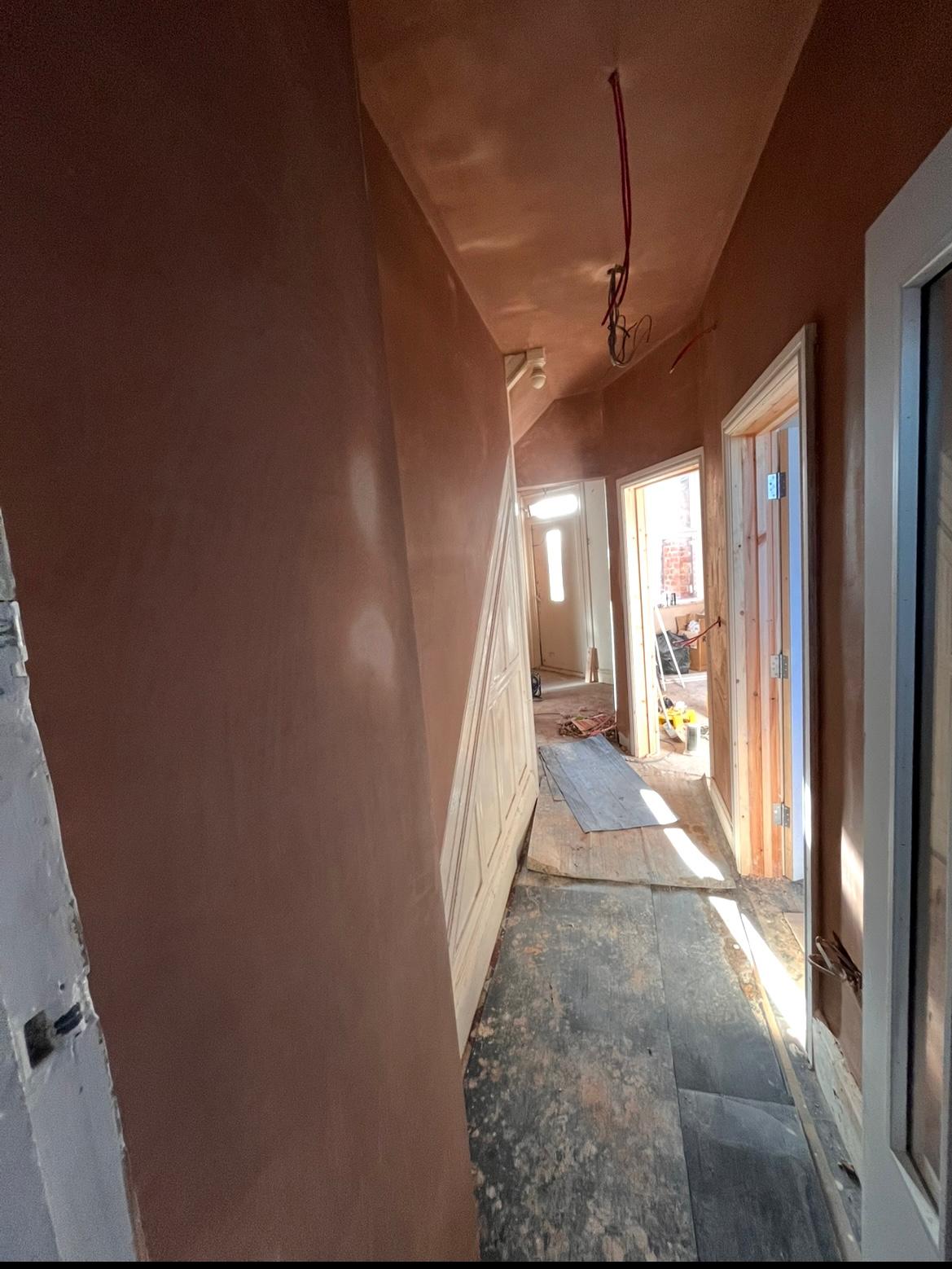 Narrow hallway freshly skimmed with two new timber-framed doorways