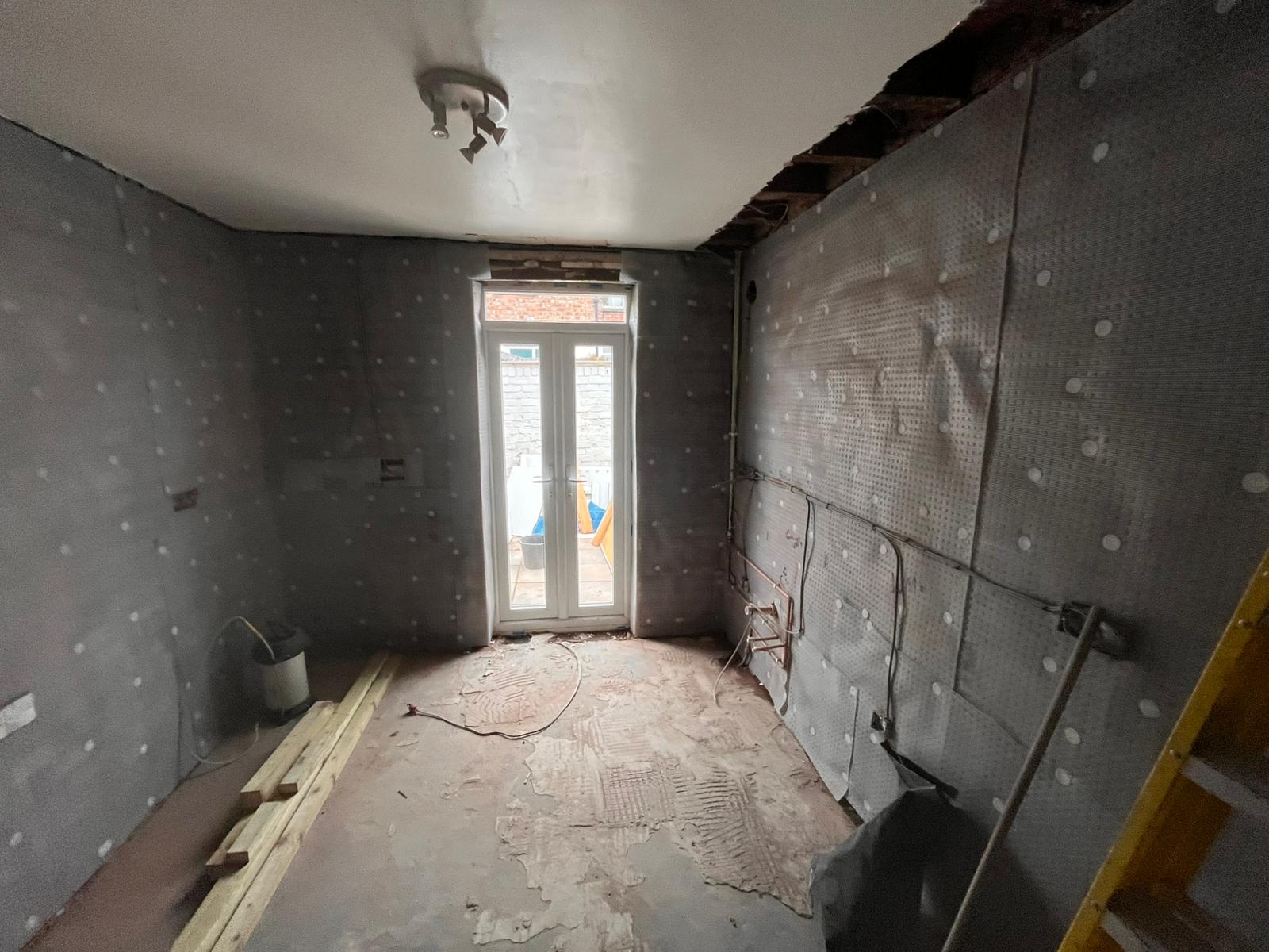 Small back room with damp-proof membrane and french doors to garden