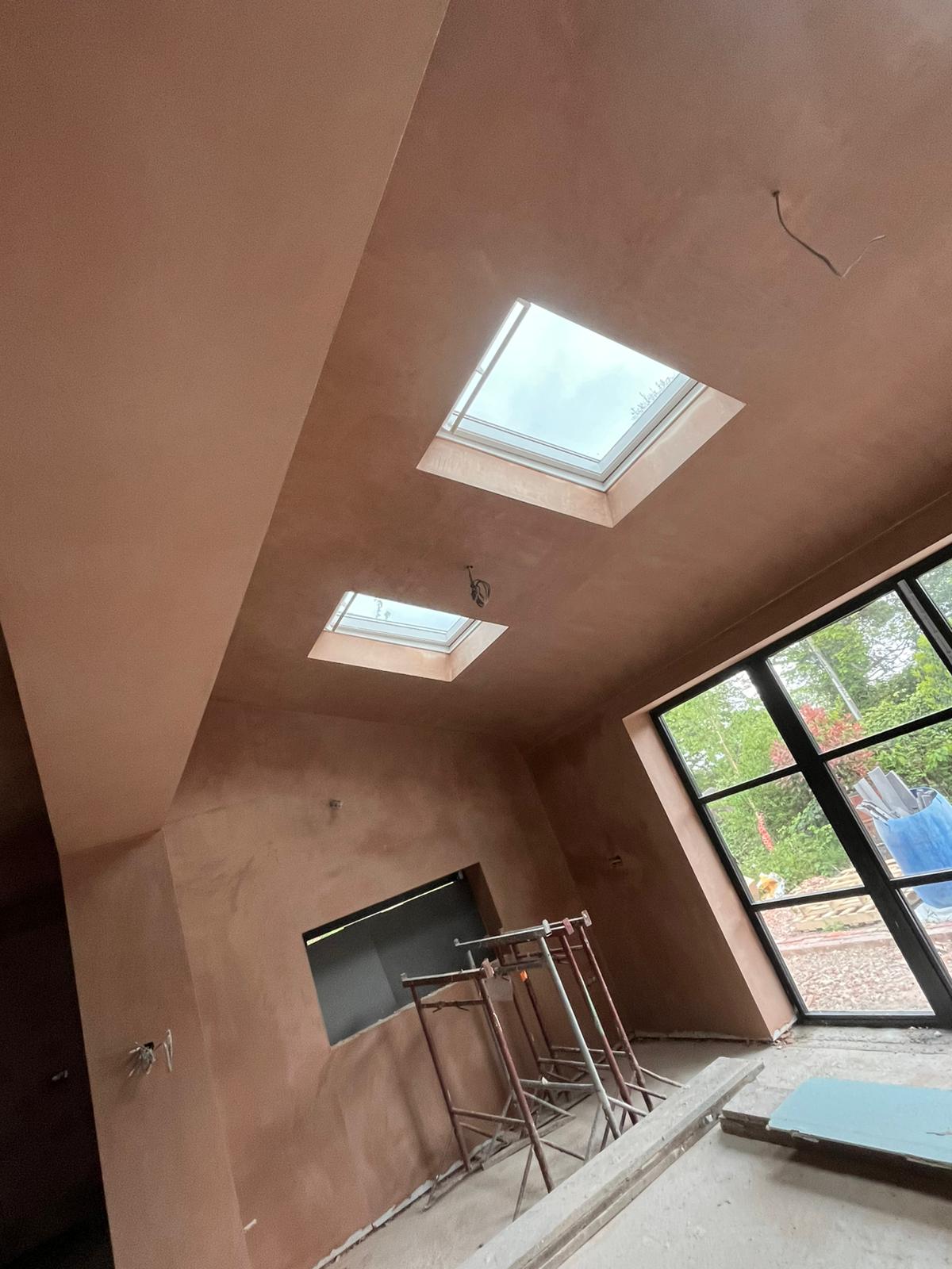 Bedroom with twin skylights and steel framed bifolds, freshly skimmed