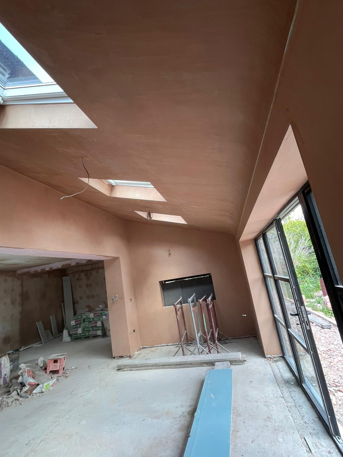 Open-plan extension ceiling and walls freshly skimmed with skylights