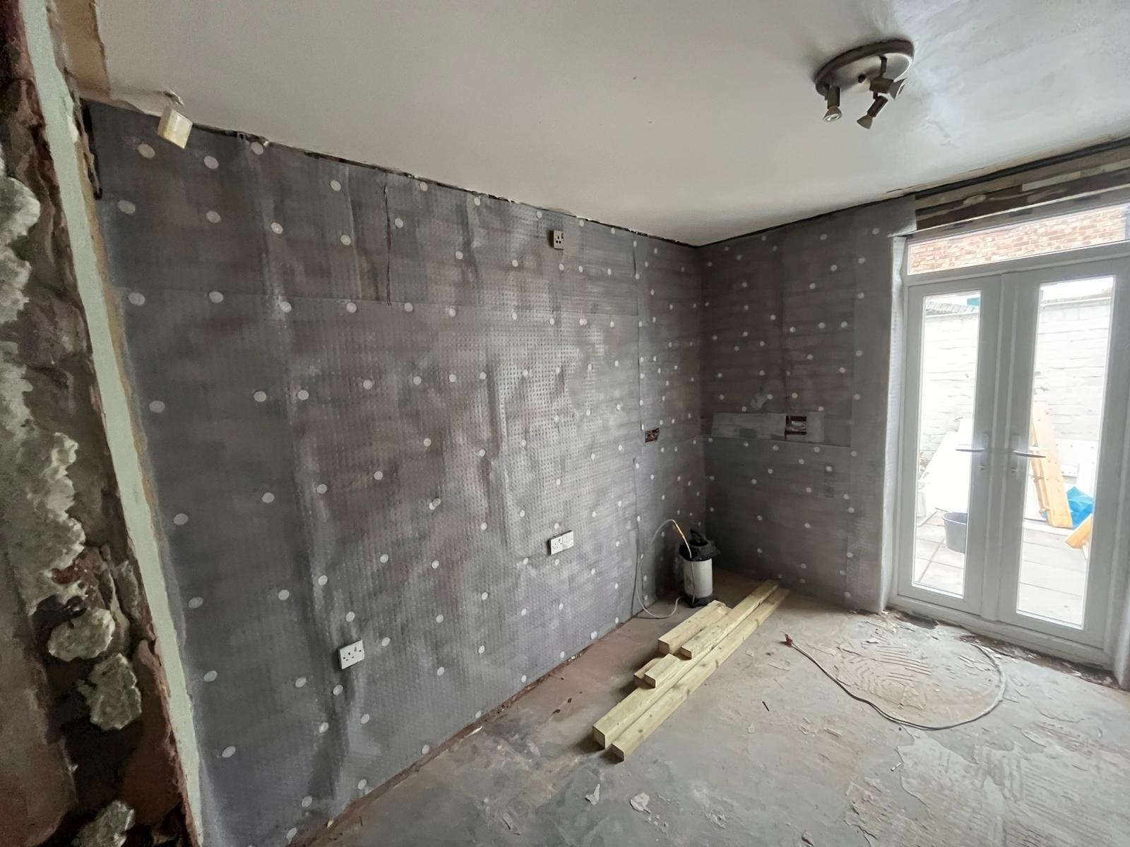 Damp-proof membrane to wall behind french doors in living room