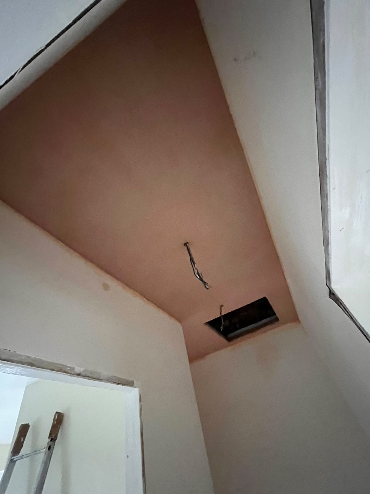 Sloping landing ceiling freshly skimmed with sharp angles