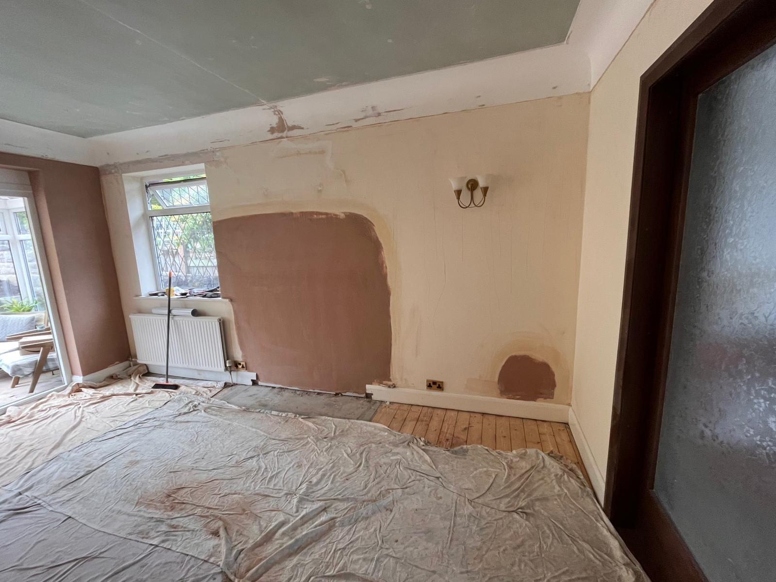 Living room with large plaster patches over chimney breast and ceiling repair