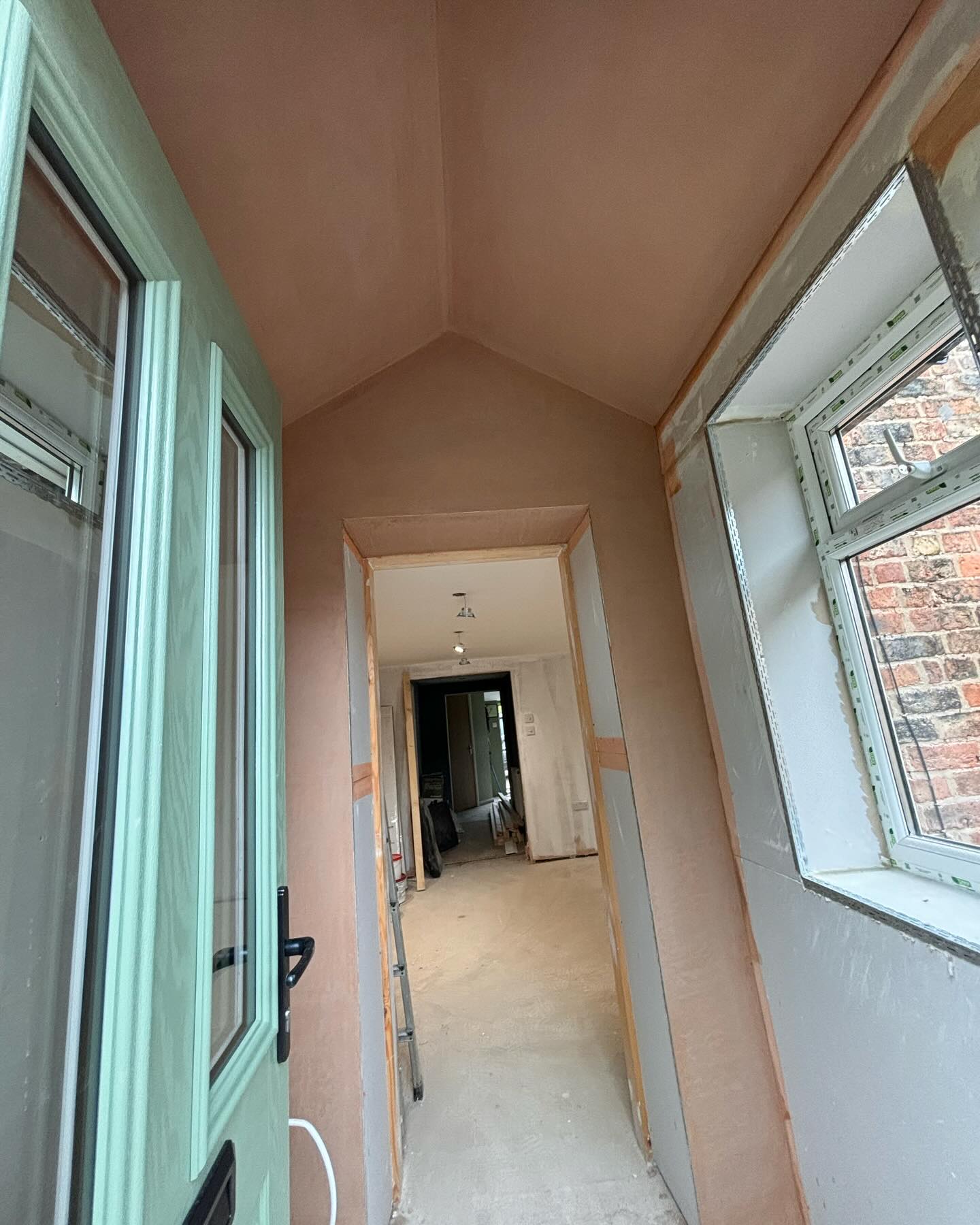 Hallway with pitched ceiling, pink plaster
